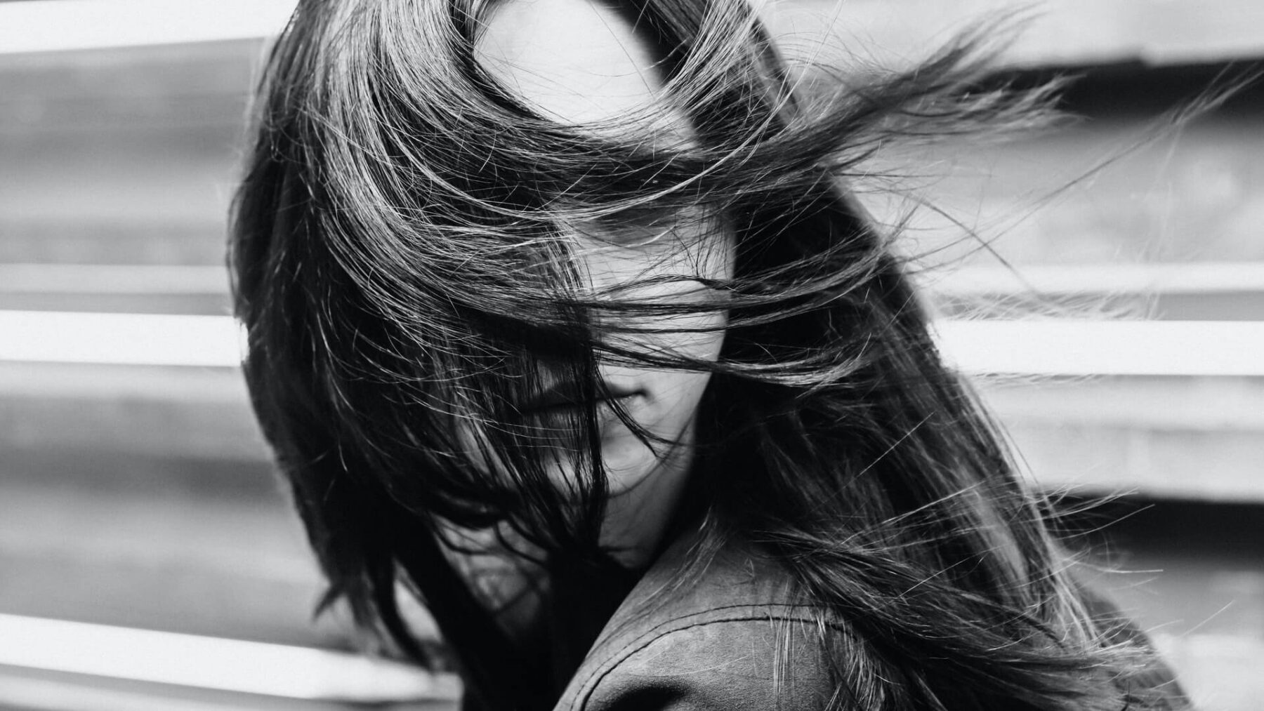 A woman with long hair is in the wind.