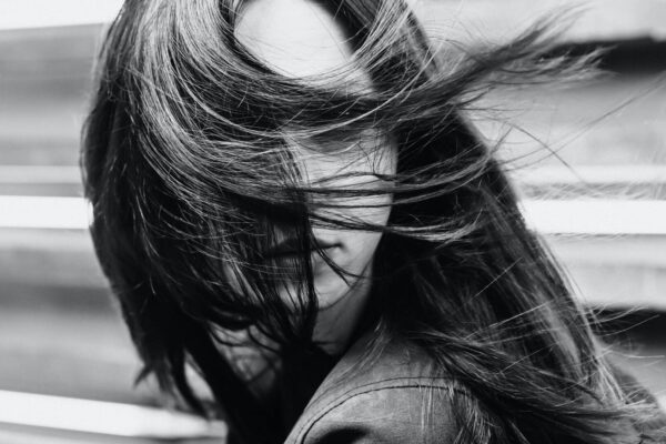 A woman with long hair is in the wind.